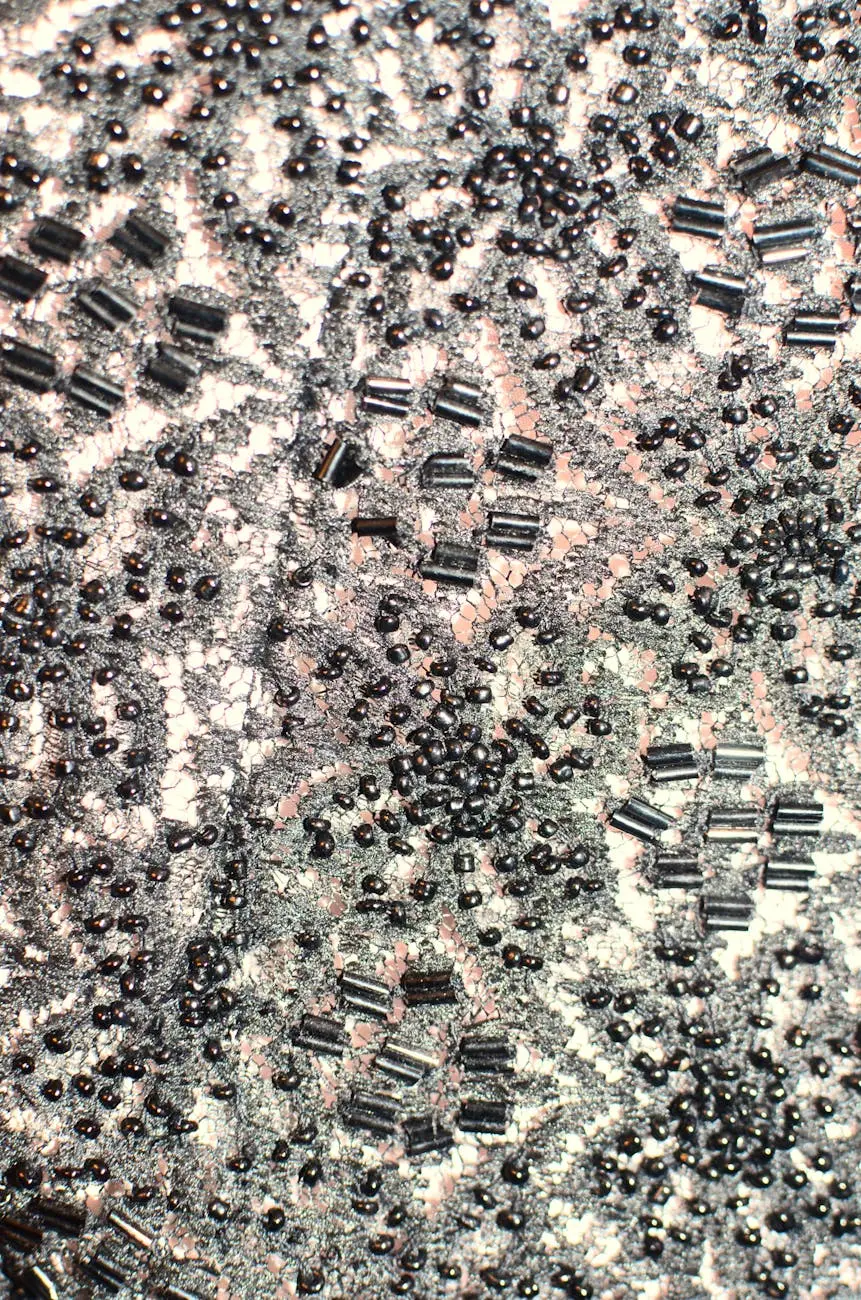 Close-up of a detailed, black beaded fabric with ornate patterns and shimmering textures.