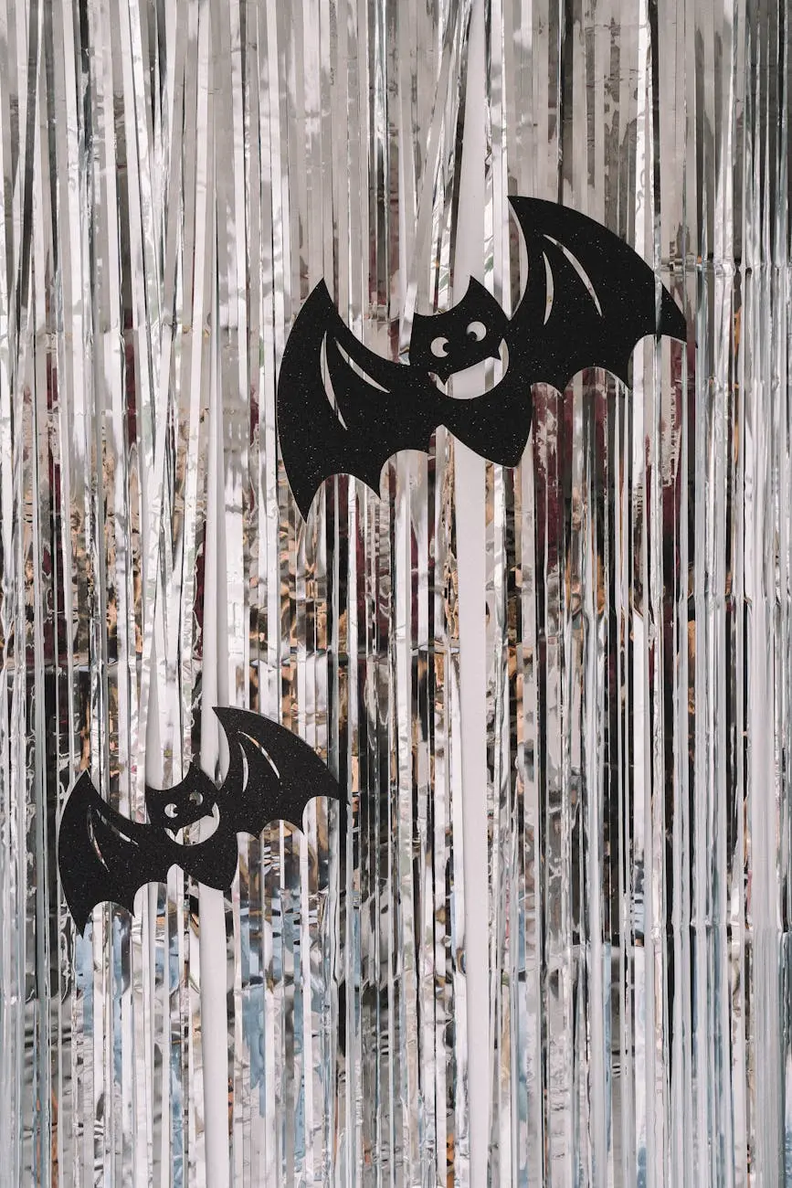 Decorative black bats against a shiny silver foil curtain for Halloween ambiance.