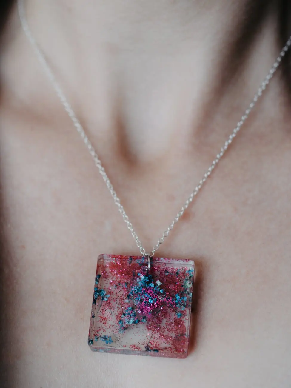 Close-up of a resin pendant necklace with colorful details. Ideal for fashion themes.