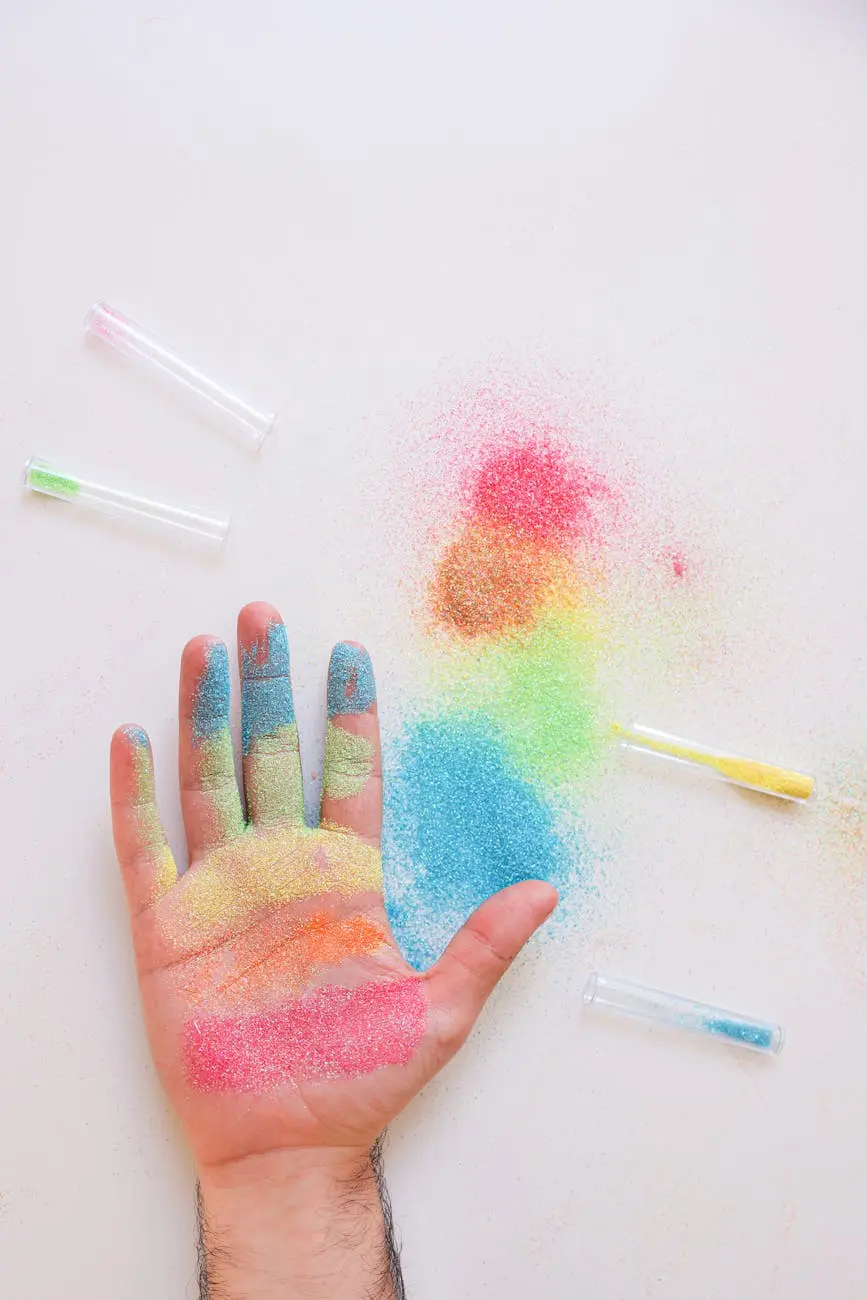 Colorful glitter spread across a hand on a white background, perfect for art and craft themes.