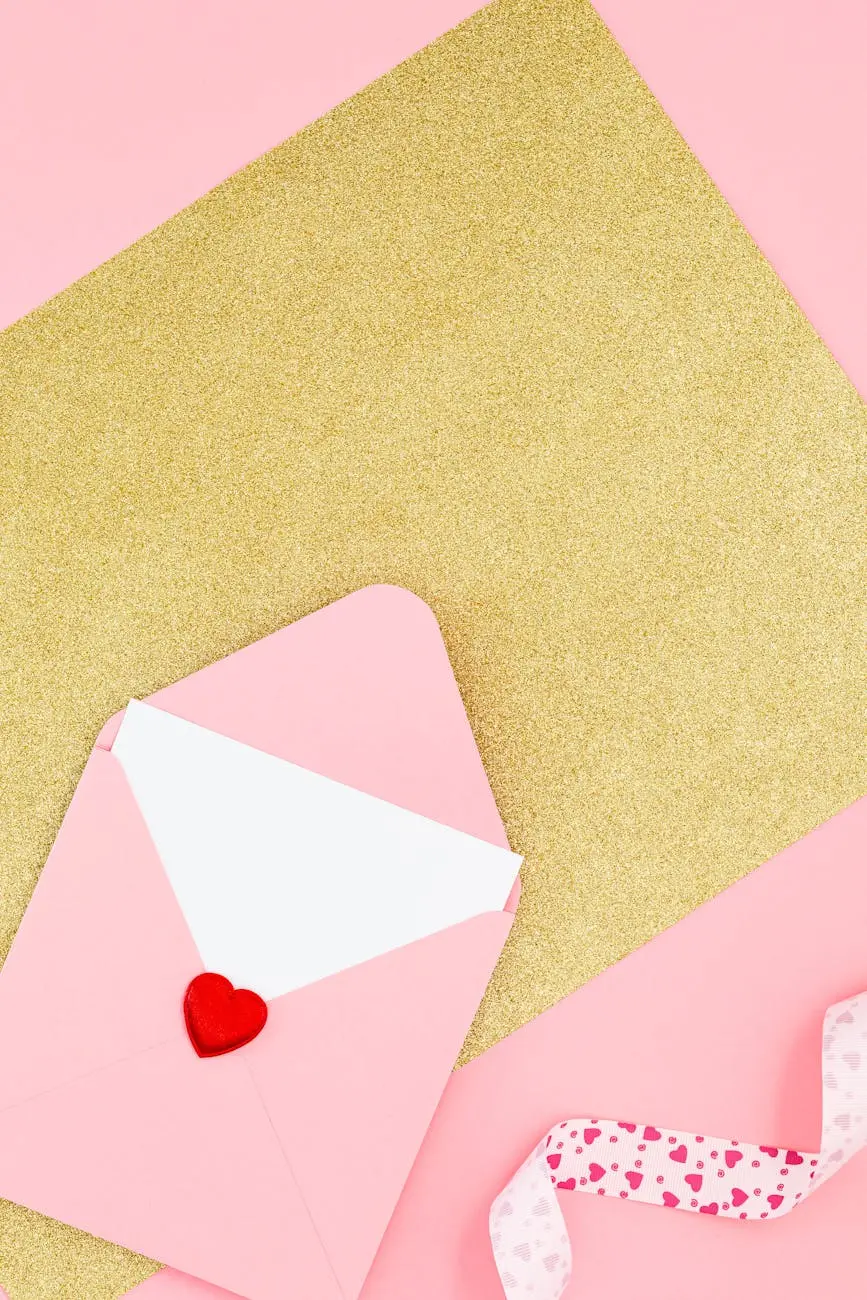 A pink valentine card and envelope with a heart seal on glittery gold paper.