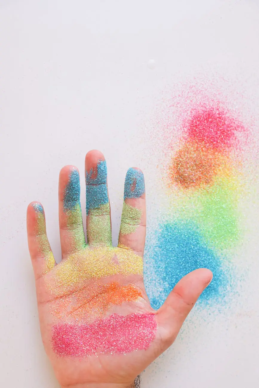 A vibrant rainbow-colored glitter covers an open hand on a white background.
